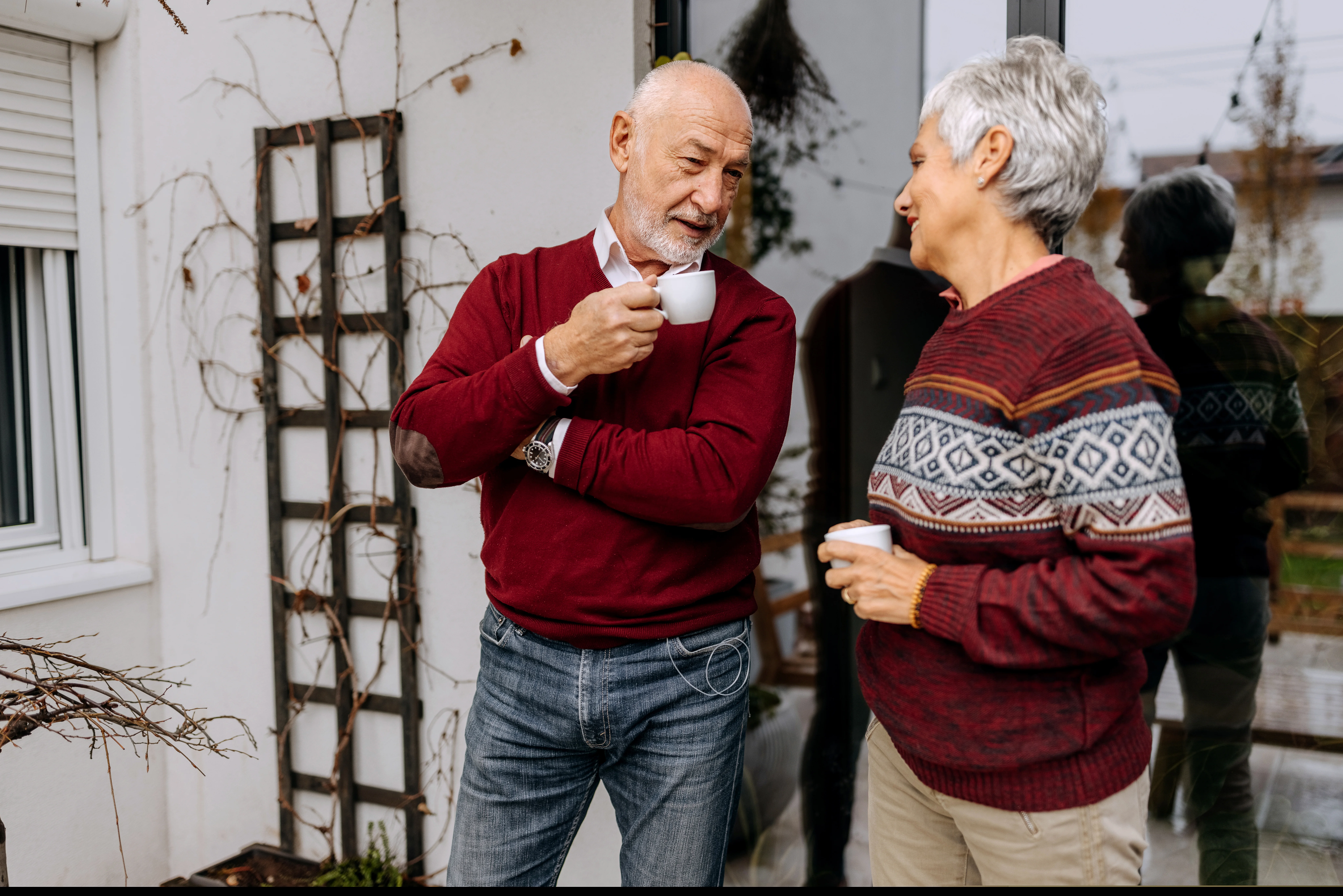 Un homme et une femme tiennent des tasses en discutant